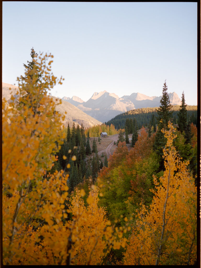 The Silverton cabin on Molas Pass framed in the changing fall colors of red, green, and yellow